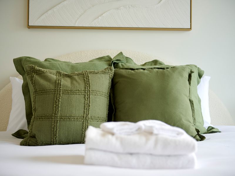 Bedroom styled with soft tones and layered cushions