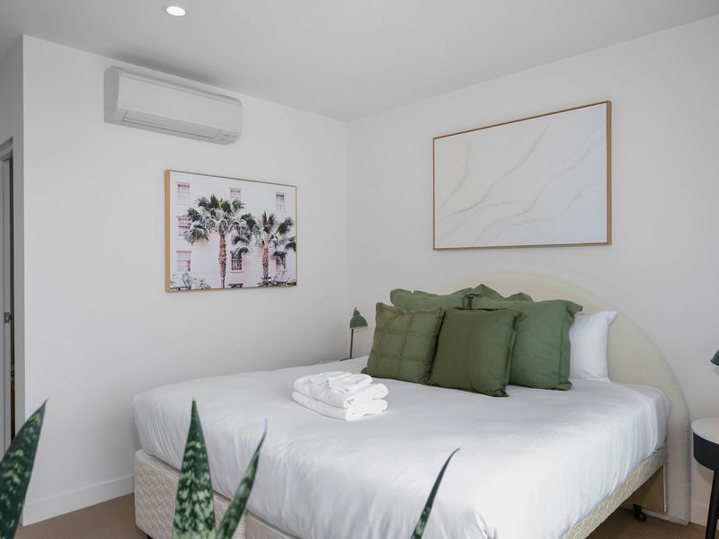 Peaceful bedroom featuring plush pillows and artwork