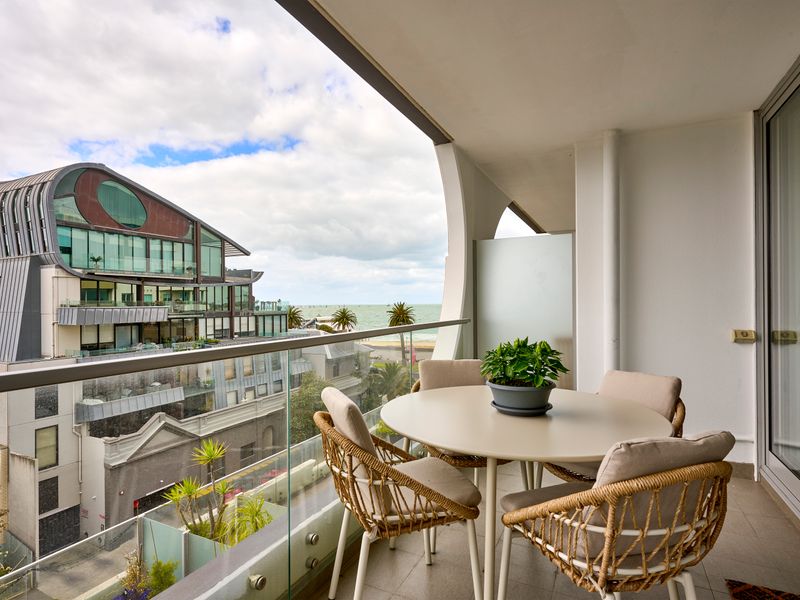 Private balcony with outdoor dining and leafy urban views