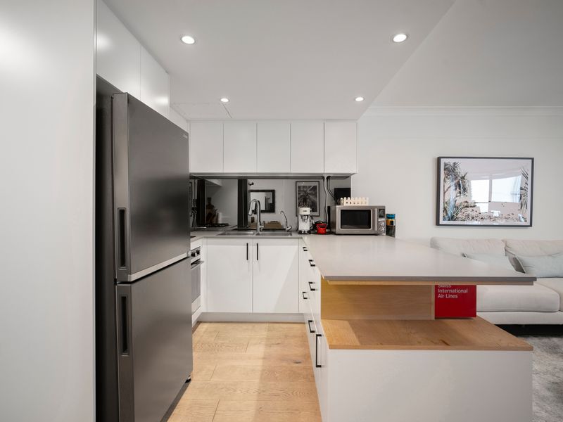 Fully equipped kitchen with stainless steel appliances and ample bench space.