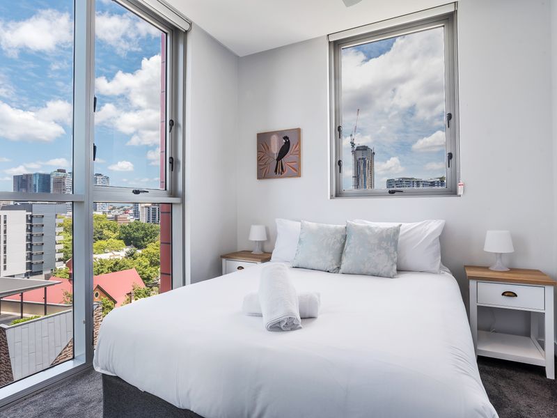 Master bedroom with plush bedding and skyline outlook