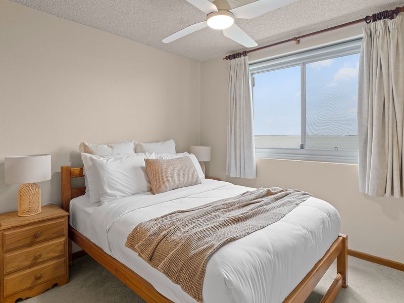 Comfortable queen bedroom with soft linens and bedside lighting