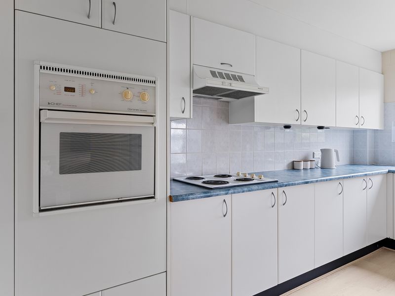 Fully equipped kitchen with oven, cooktop, and ample storage