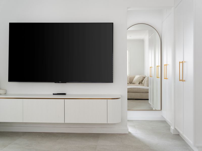 Living area with large TV and built in storage