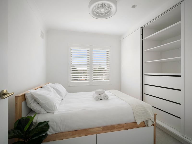 Bright main bedroom with crisp white interiors