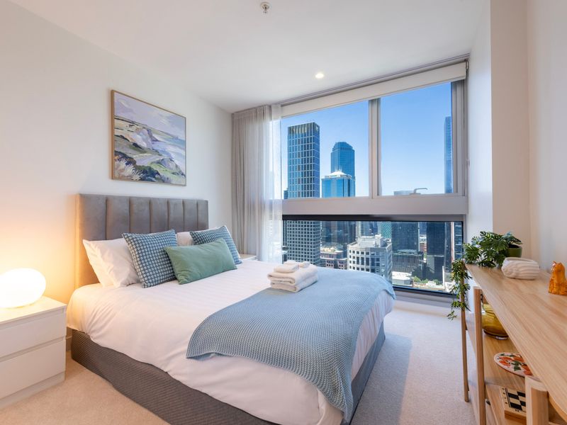Second bedroom with plush bedding and city outlook