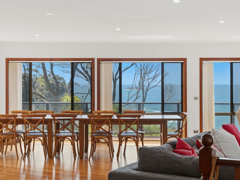 Dining area surrounded by windows and coastal vistas