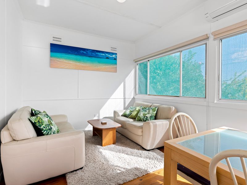 Sun-filled lounge with cozy seating and coastal artwork