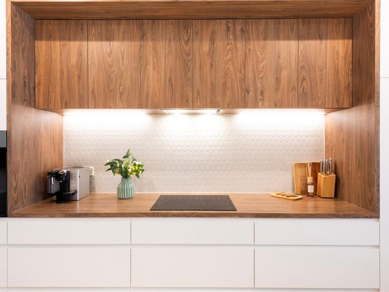 Designer kitchen detail with warm timber cabinetry and soft lighting.