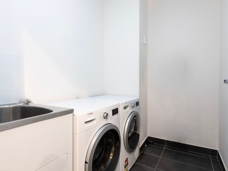 Dedicated laundry room with washer, dryer, and utility sink.