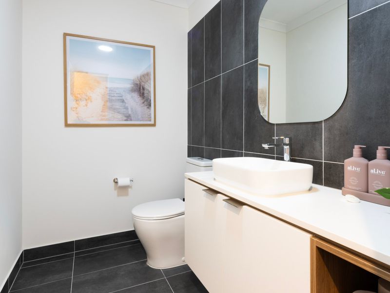 Stylish modern powder room with stone tiles and elegant vanity.