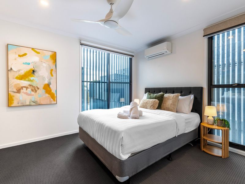 Comfortable queen bedroom with large windows and fresh linens.