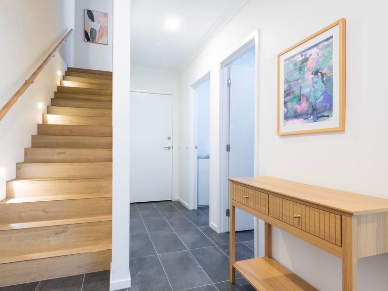 Bright & welcoming entryway with sleek timber stairs and modern finishes.