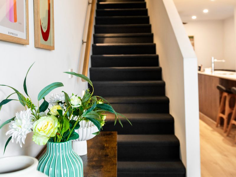 Statement staircase styling with greenery and natural light.