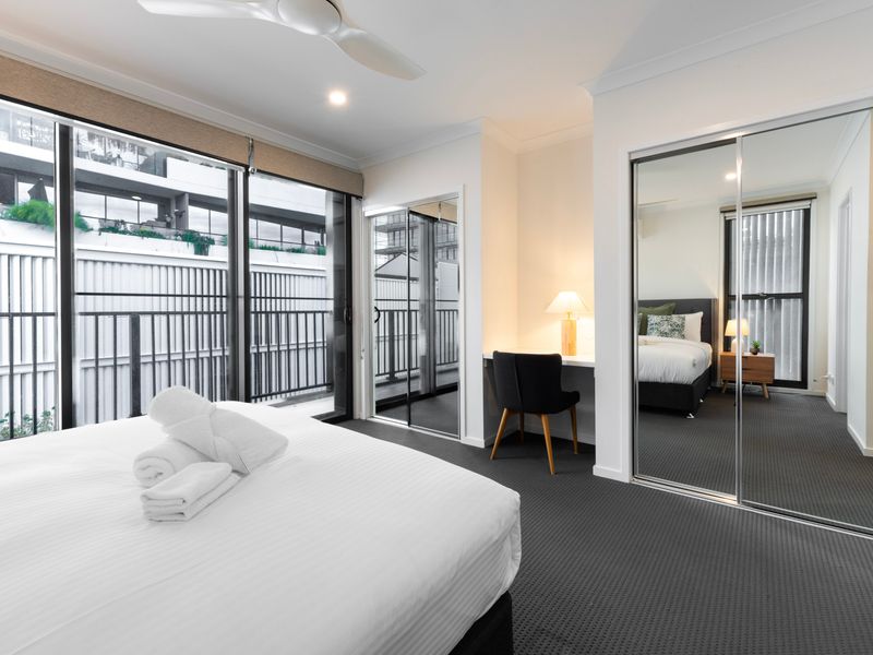Bedroom with indoor-outdoor flow and full-height windows.
