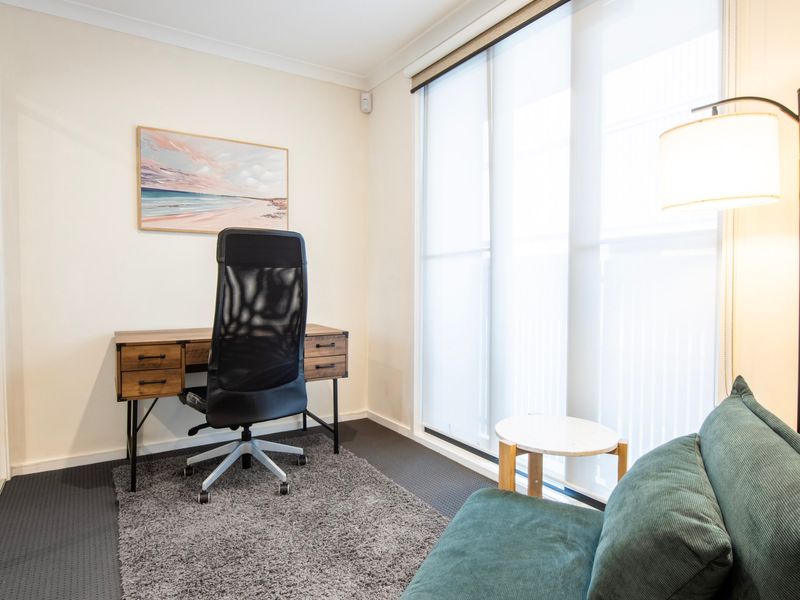 Quiet work-from-home nook with desk, natural light, and comfortable seating.