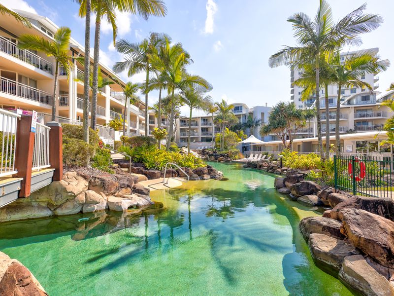 Resort-style communal pool surrounded by lush tropical gardens – perfect for a refreshing dip or relaxing afternoon in the sun.