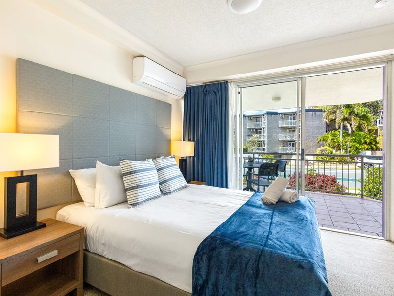 Double bed with balcony access for comfortable sleep and split air conditioner