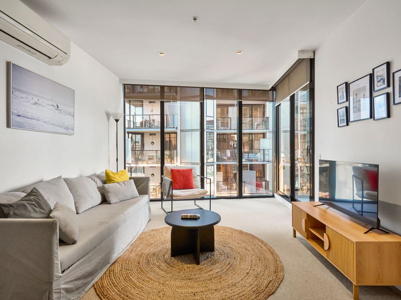 Bright open-plan living area with floor-to-ceiling windows and city views.