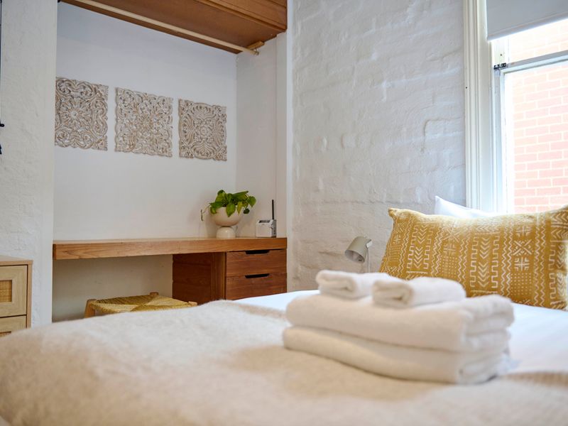 Sunlit bedroom with plush pillows and fresh towels