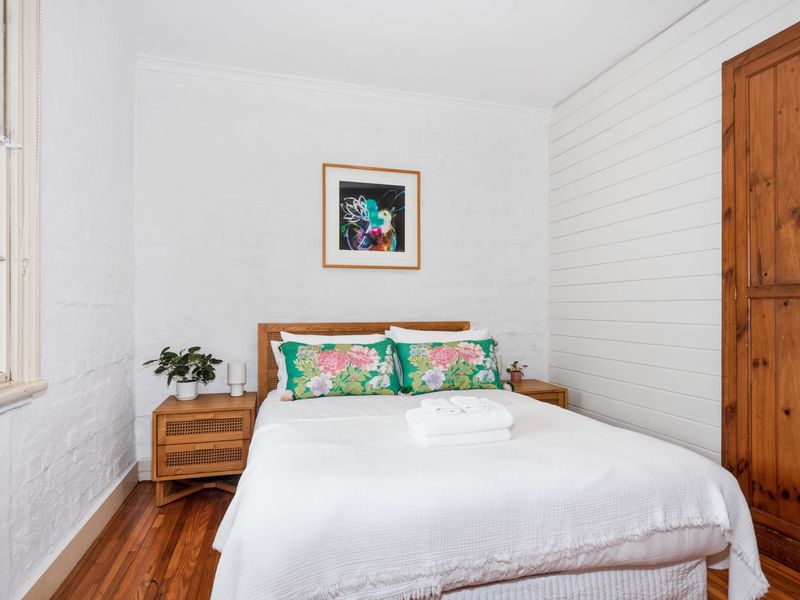 Serene bedroom with crisp linens and warm timber touches