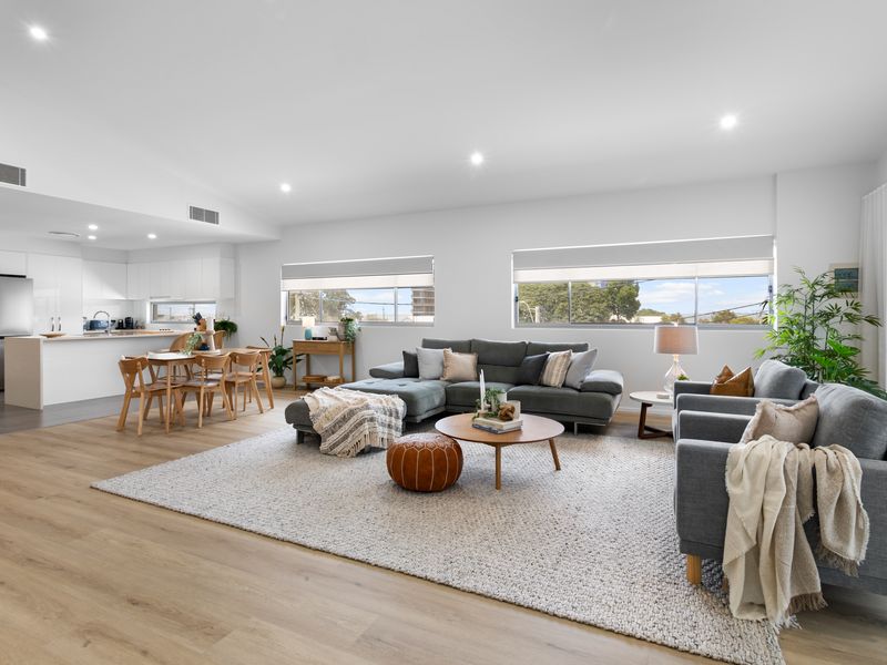 Spacious open-plan living area with comfortable seating and a bright modern kitchen.