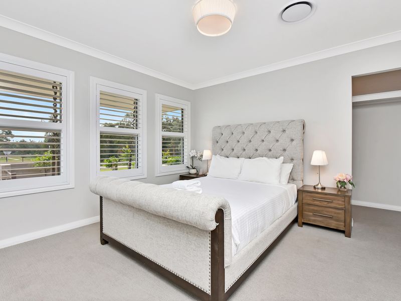 Wake up to sunlight in this serene white bedroom.