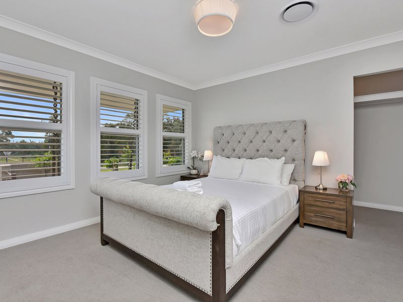 Wake up to sunlight in this serene white bedroom.