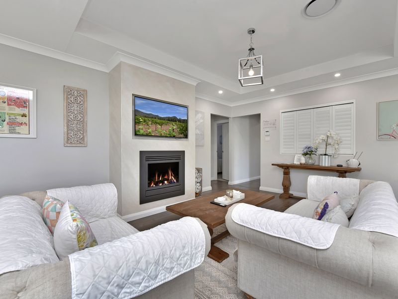 Cozy white living room with a brown centerpiece and firepit warmth.