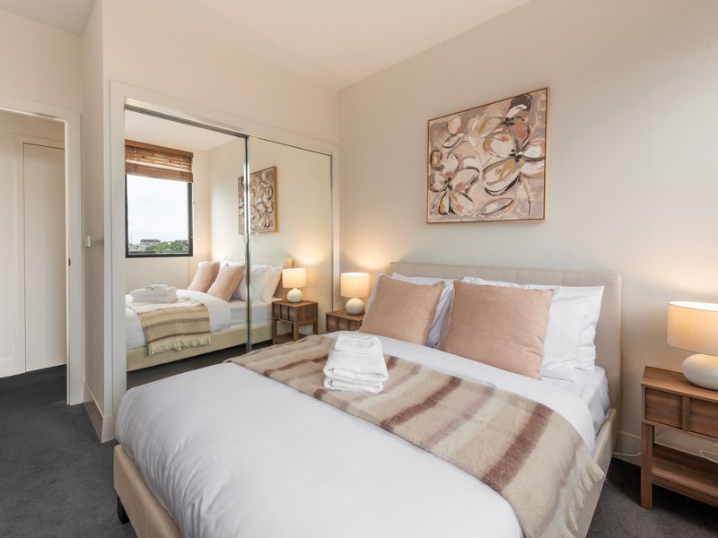 Double bed room with mirrored wardrobe and warm styling throughout.