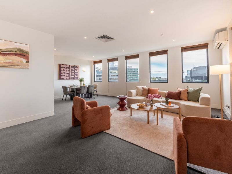 Expansive living room with multiple zones and natural light