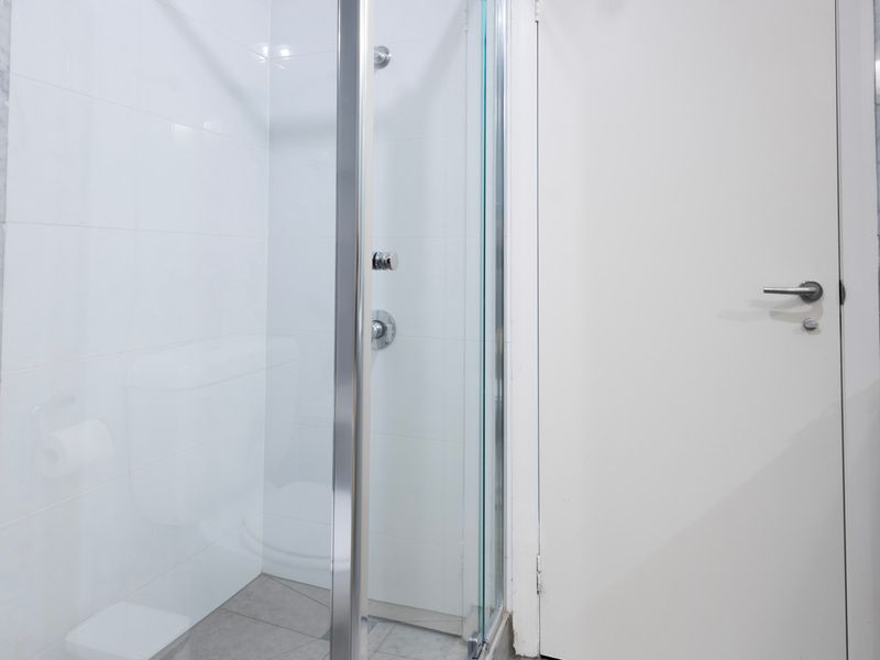 Walk in shower with sleek tiled interior and clean, modern design