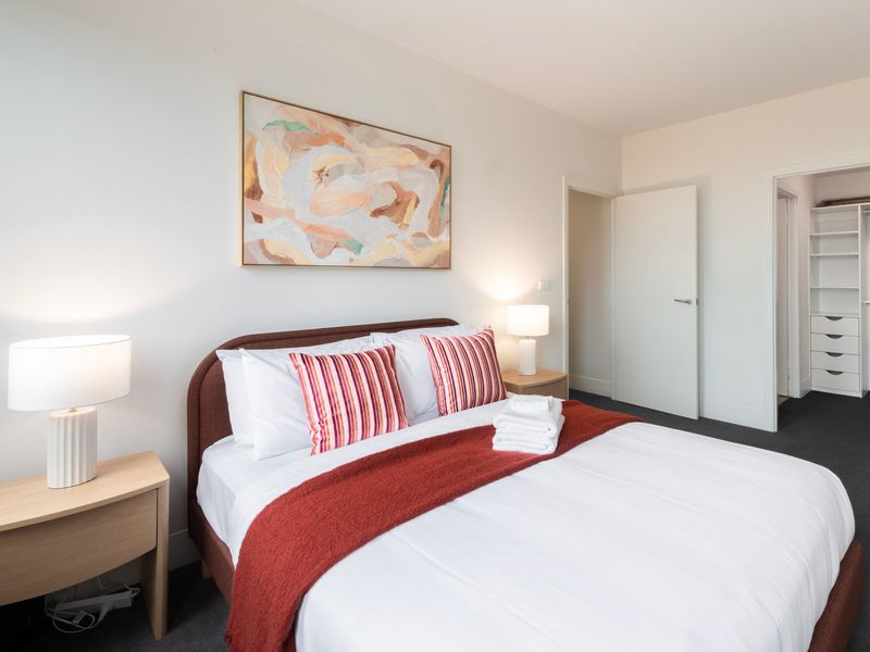 Primary bedroom featuring a comfortable queen bed, soft lighting and a calm, restful design