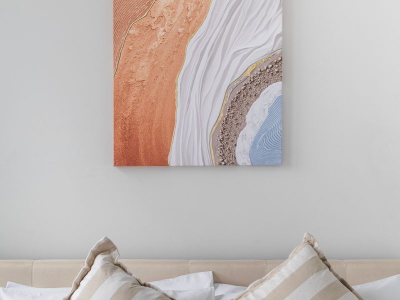 Stylish artwork enhances the calm, modern bedroom setting