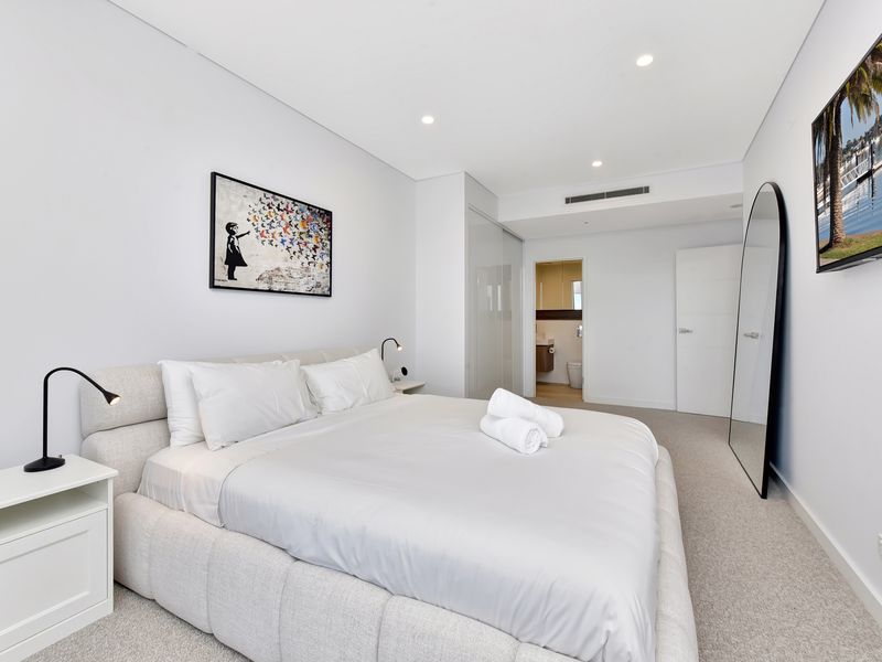 Spacious master bedroom with modern furnishings.