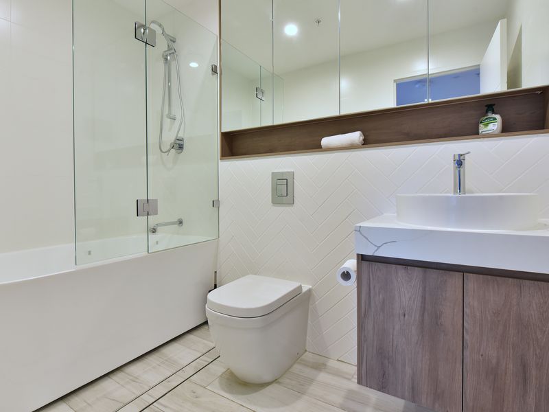 Sleek modern bathroom with shower and vanity.