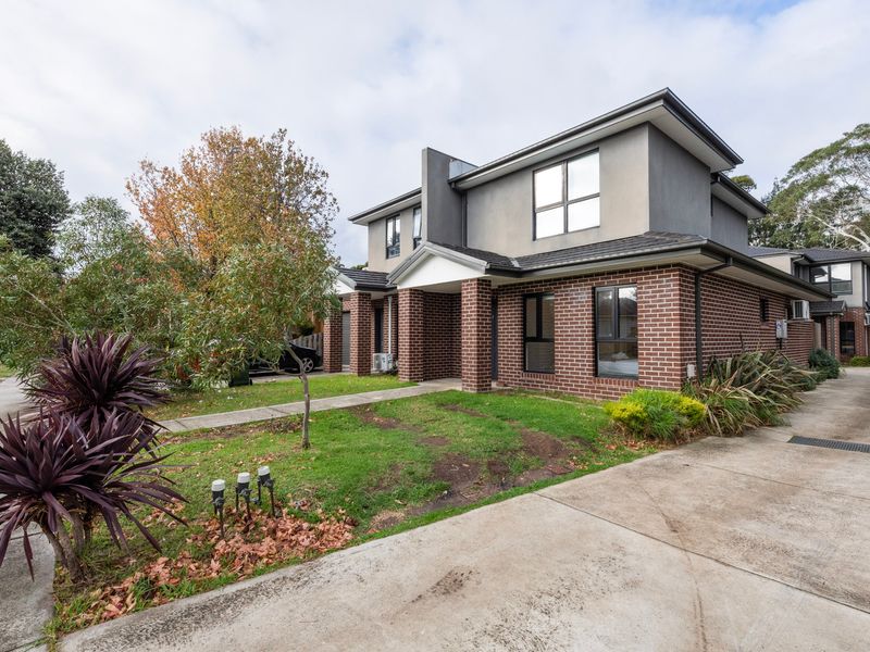 Townhouse exterior with garage parking and landscaped surrounds.