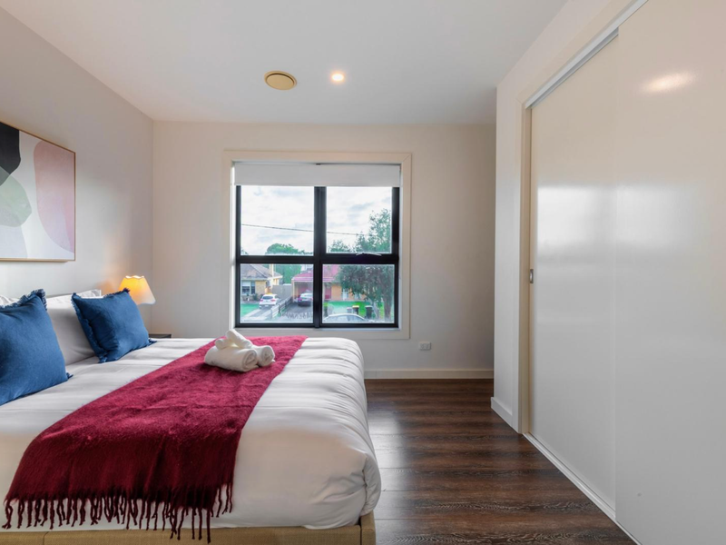 Spacious Queen bedroom with soft furnishings and plenty of natural light.