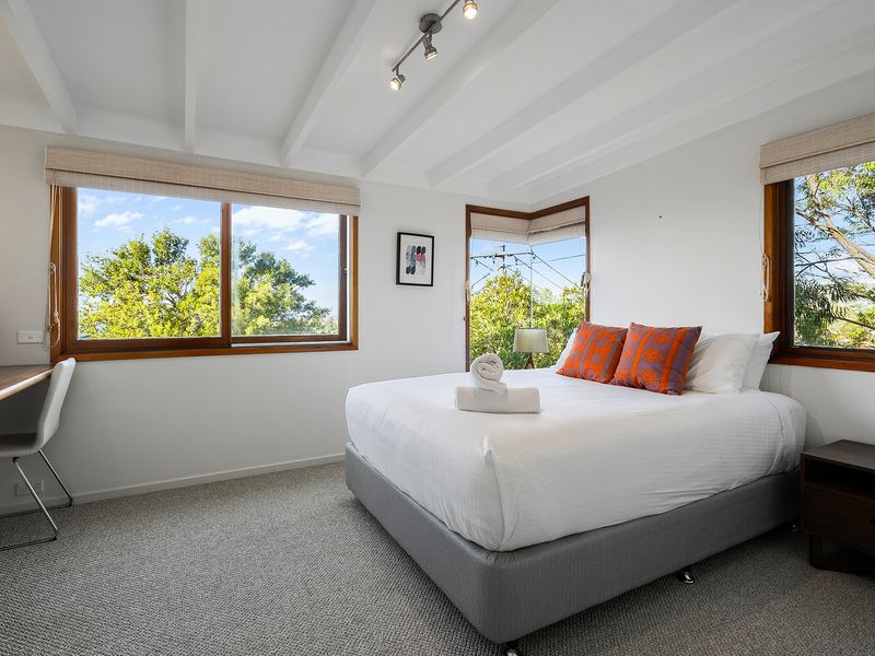 A peaceful bedroom bathed in natural light from every angle.