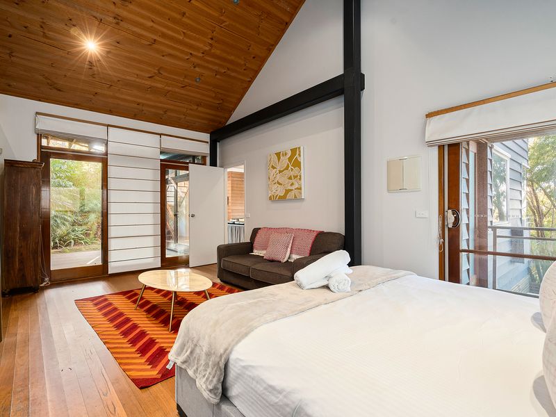 A spacious bedroom retreat with a cozy sofa and open, airy feel.