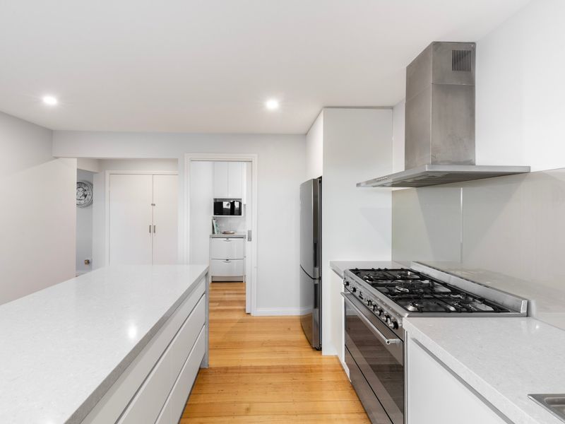 Fully equipped modern kitchen with stone benchtops and quality appliances