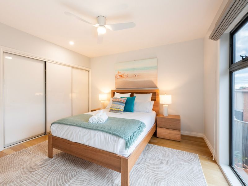 Queen bedroom with natural light and coastal outlook