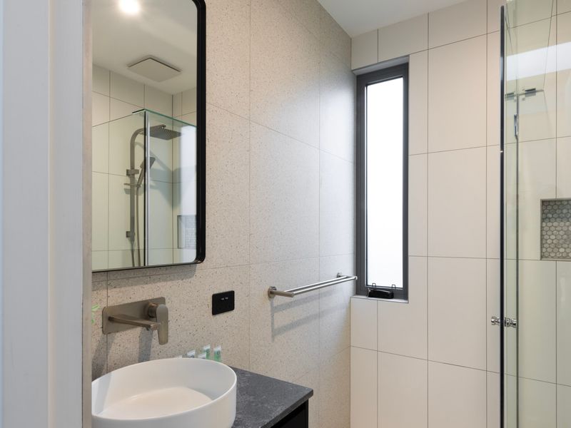 Modern ensuite bathroom with shower, vanity, and toilet
