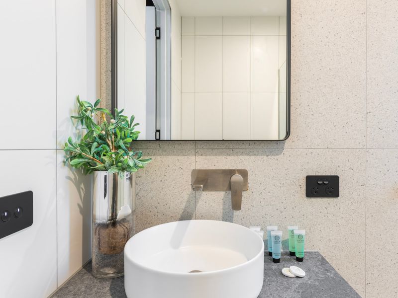 Modern ensuite bathroom with shower, vanity, and toilet