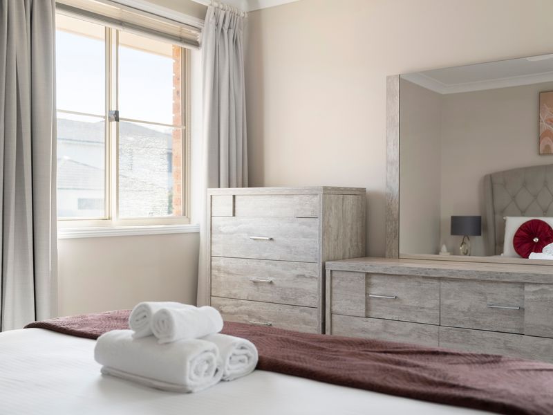 Large windows fill the bedroom with beautiful natural light.