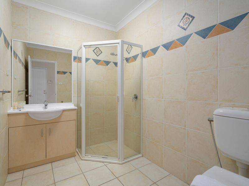 Freshen up in the practical bathroom featuring a shower, vanity, and separate toilet.