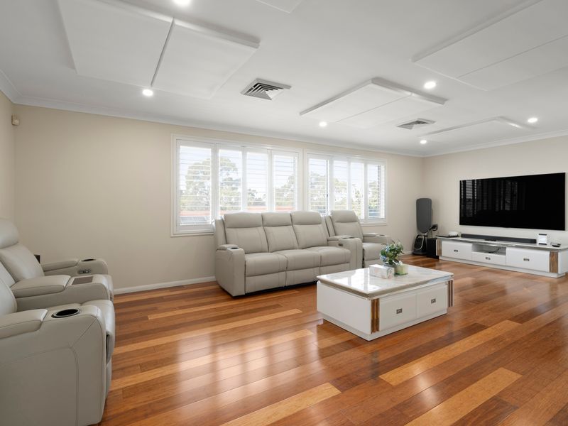 Relax in the spacious family room featuring comfortable seating and polished timber floors.