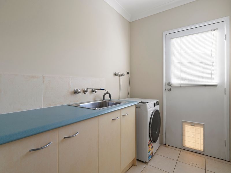 A dedicated laundry with washer, sink, and bench space adds convenience for longer stays.