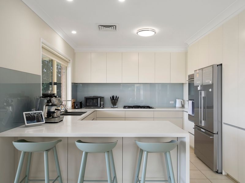 The spacious kitchen features a large island bench, modern appliances, and plenty of room for group meals.