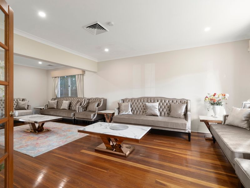 Unwind in the stylish formal lounge featuring timber flooring and comfortable seating.
